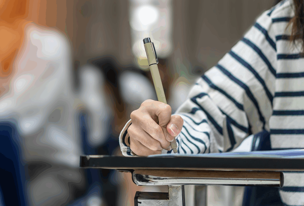 Sportzaal ingericht als examenruimte met tafels en stoelen op afstand